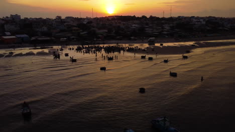Local-Vietnamese-sorting-seafood-catch-for-distribution-in-early-morning,-aerial-drone-shot