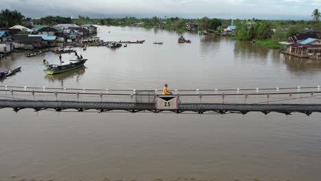 aerial martapura river daily activity people walking via bridge, landmark of banjarmasin with boat river in the morning