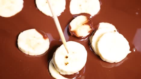 banana slices skewered and dipped in chocolate