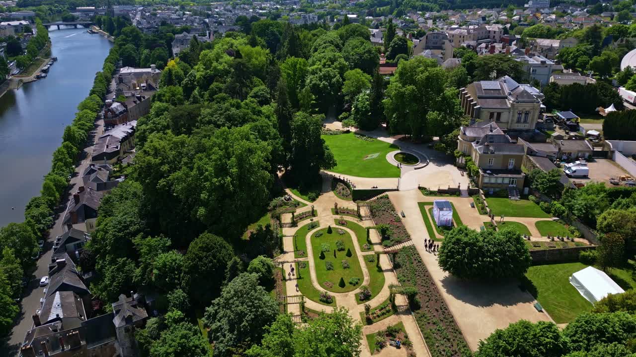 Jardin de la Perrine in Laval with trees, Mayenne river and cityscape in France. Aerial drone flyback