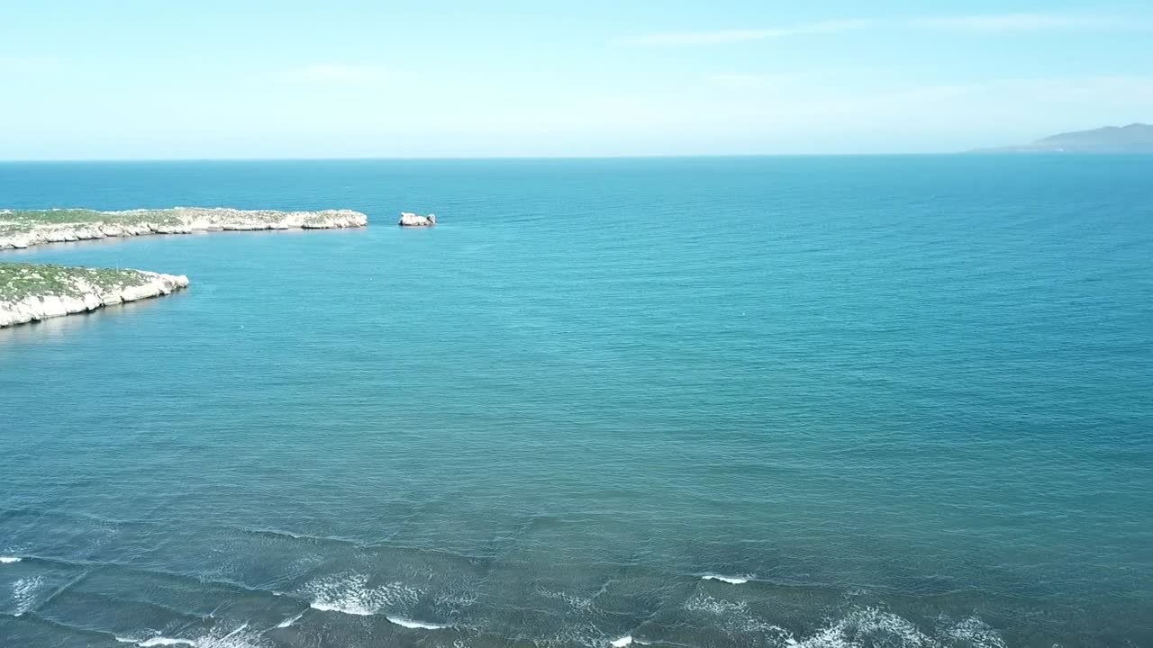 Stunning aerial view of small rocky islands and islets located near the sandy shore. Turquoise clear Mediterranean water surrounding the rock formations