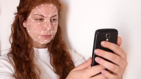 close up of a young woman with red hair, with a white shirt on a white background, while holding a phone in front of her face with facial recognition high tech animation with a glow effect on her face