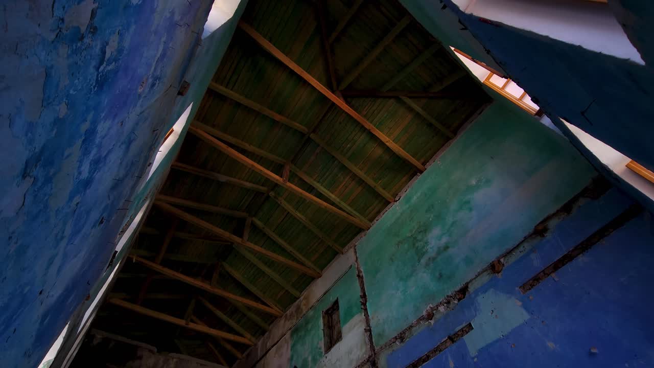 Vecchia casa in pietra abbandonata di tre piani con architettura mediterranea in Albania, pareti dipinte in diversi colori per ogni piano, tetto ricostruito sopra le rovine