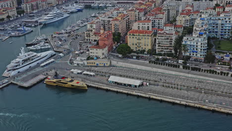 Nice-France-Aerial-v4-birds-eye-view-capturing-luxury-yachts-docked-at-lympia-port-and-beautiful-cityscape-of-quartier-du-port,-castle-hill-and-old-city---July-2021