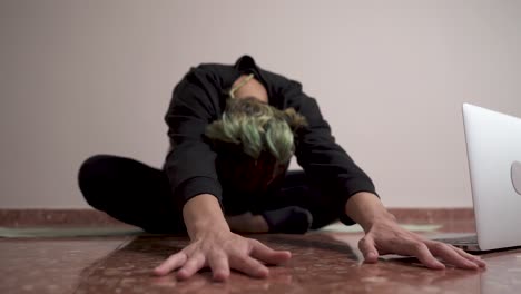 Woman-with-braids-stretching-her-back-in-online-yoga-class