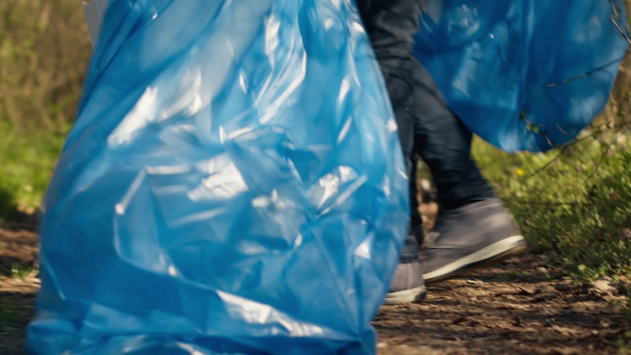 Diversi attivisti puliscono la spazzatura in un sacchetto per lo smaltimento dei rifiuti