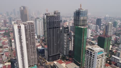 urban skyline residential and commercial buildings construction in phnom penh city covered in hazy sky due to air pollution, climate change, aerial view