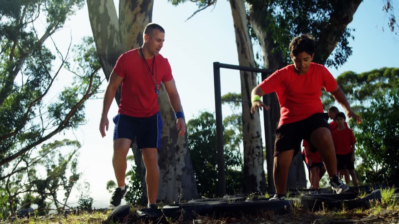 entrenador entrenando a los niños en el campamento de entrenamiento