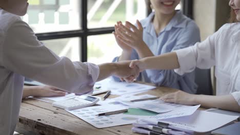 un primer plano de personas de negocios multiétnicas irreconocibles de pie una frente a la otra haciendo un acuerdo y haciendo un apretón de manos.