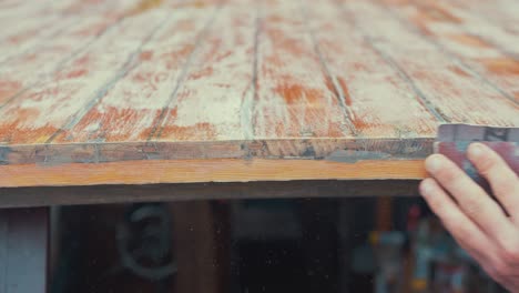 hand sanding edge of wooden boat wheelhouse cabin planks close up