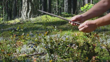 Un-Hombre-Encuentra-Una-Hoja-De-Daga-De-Arma-De-Rifle-En-El-Musgo-Del-Bosque-1