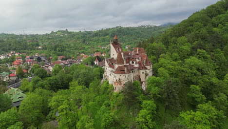 aerial view: majestic bran castle, also known as dracula's castle, stands on a hilltop surrounded by a dense forest in transylvania, romania