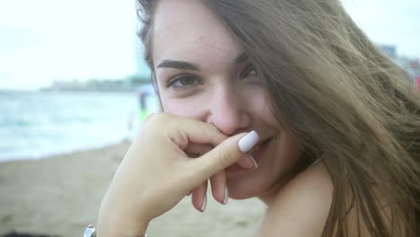 Porträt-Eines-Schönen-Mädchens,-Das-Am-Strand-Sitzt.-Frau-Mit-Wehendem-Haar-Im-Wind