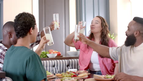 enjoying breakfast together, diverse friends drinking milk and sharing meal at table