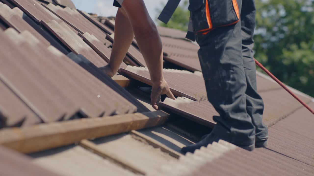 Roofer is removing tiles on a roof