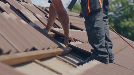 roofer is removing tiles on a roof