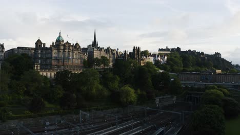 Toma-Aérea-Ascendente-Que-Muestra-La-Estación-De-Tren-Waverley,-El-Museo-En-El-Montículo-Y-El-Centro-En-Edimburgo,-Escocia