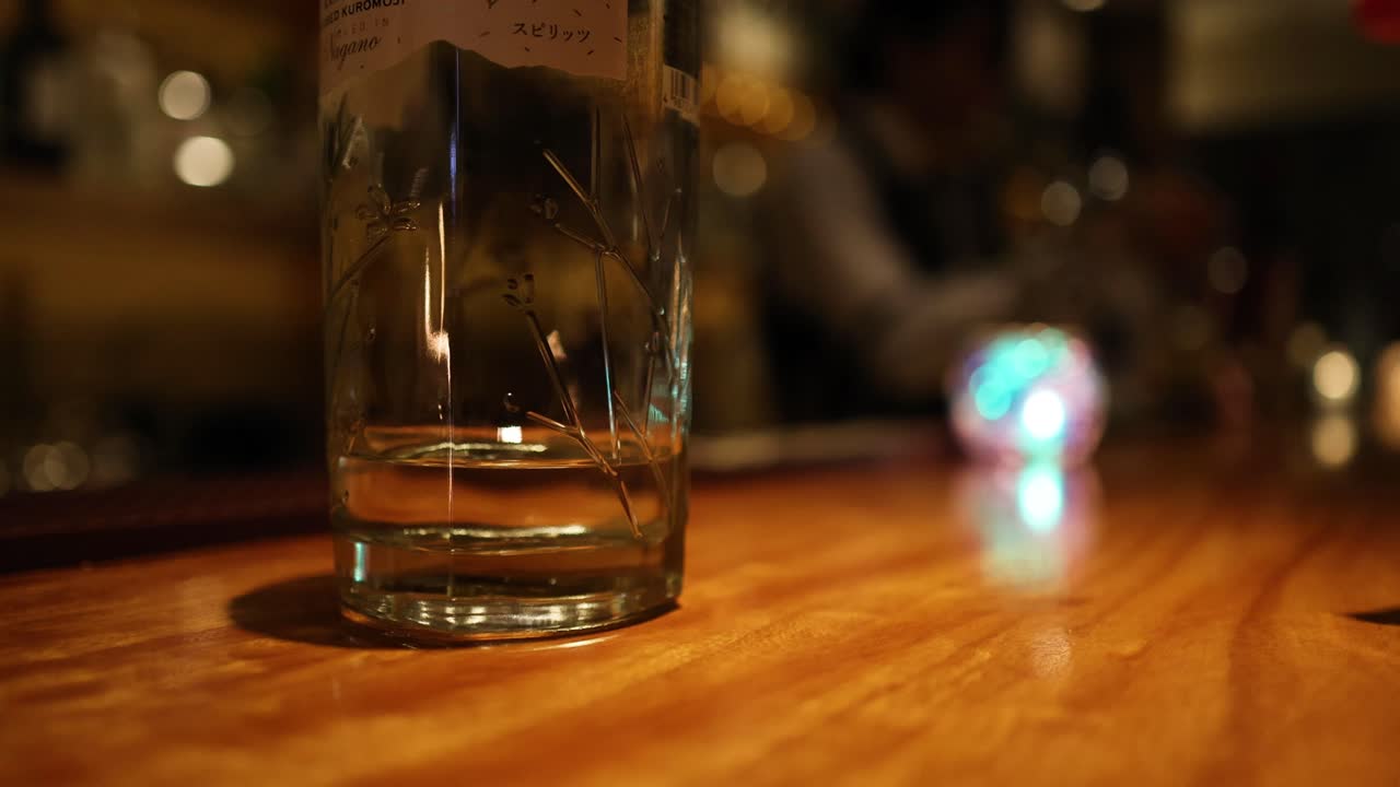 한 손이 술집에서 유리를 잡는 장면