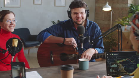 dos presentadoras de podcast entrevistando a un músico masculino