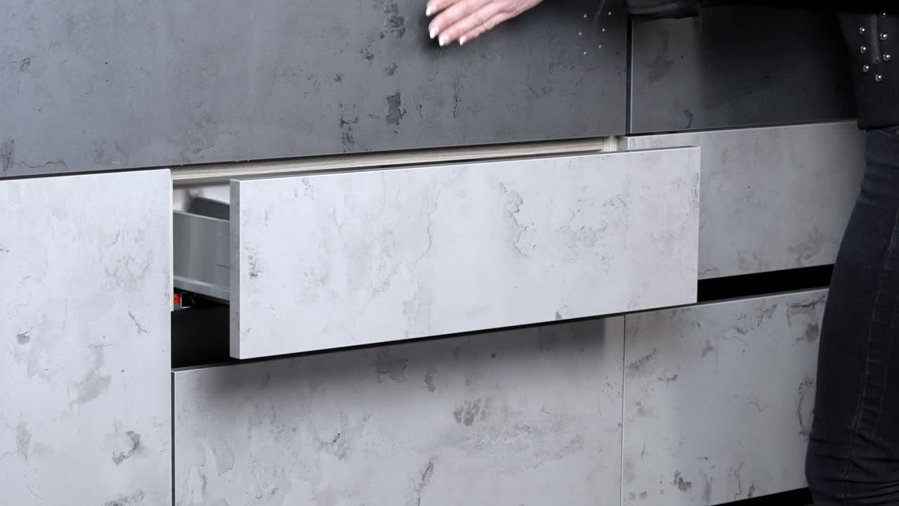 mujer con uñas pintadas abre y cierra el cajón del armario