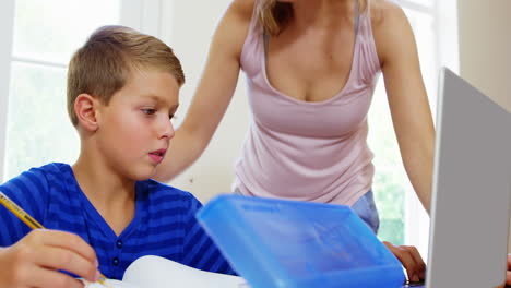 madre ayudando a su hijo a usar la computadora