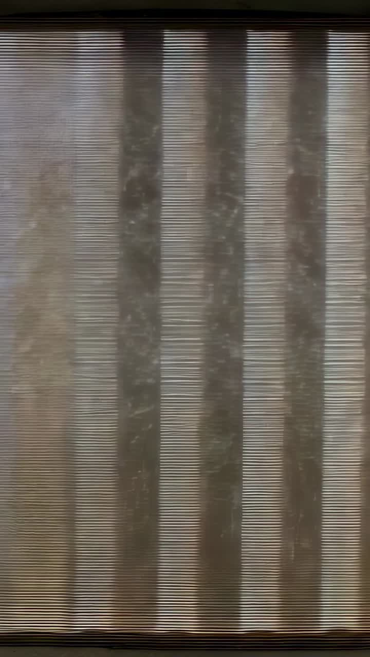 Vertical video: Showing sheer blind revealing three dark bars at window, rain starting droplets