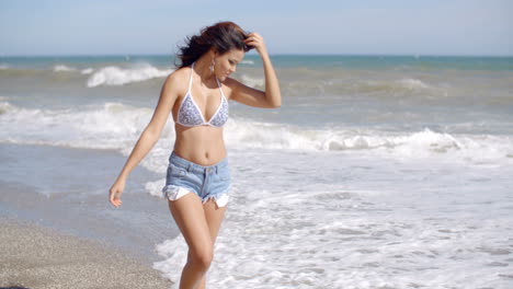 Mujer-Juguetona-Jugando-En-Las-Olas-En-Una-Playa