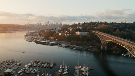 drone aerial push past aurora bridge on lake union with seattle skyline in background and lake rowers