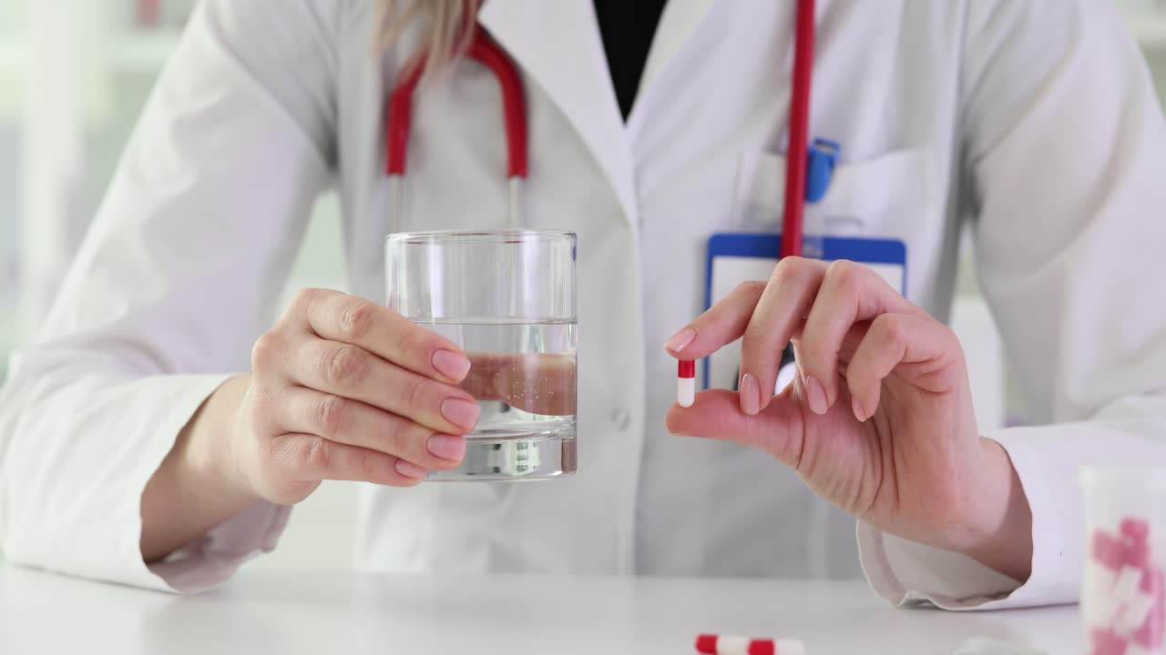 Doctor holding pill and glass of water