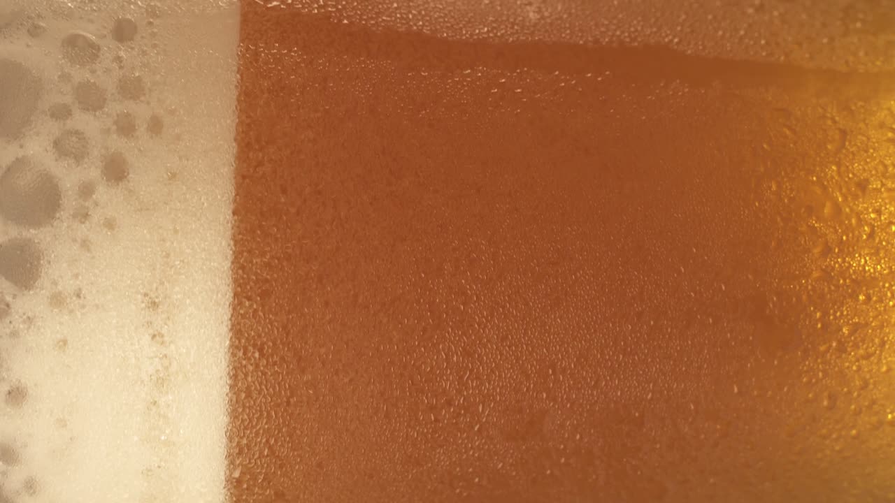 primer plano de un vaso de cerveza giratorio, video de retrato