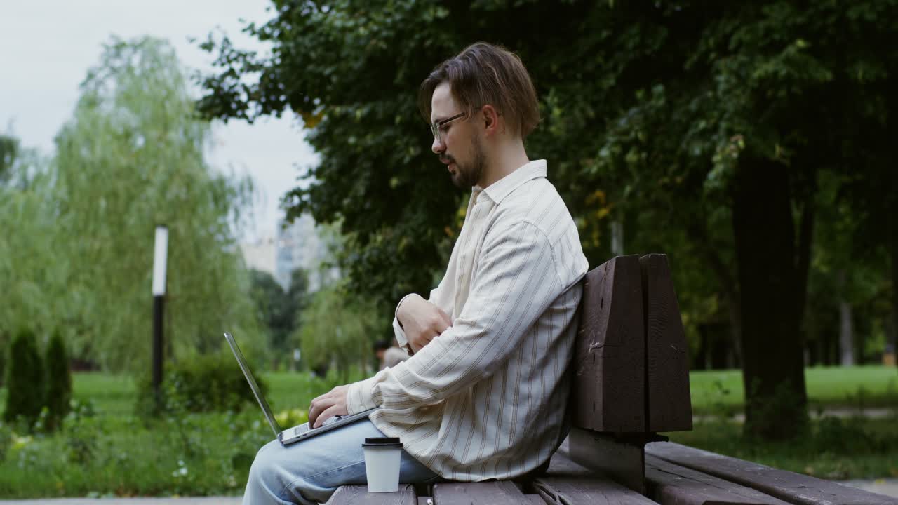 человек работает на ноутбуке в парке