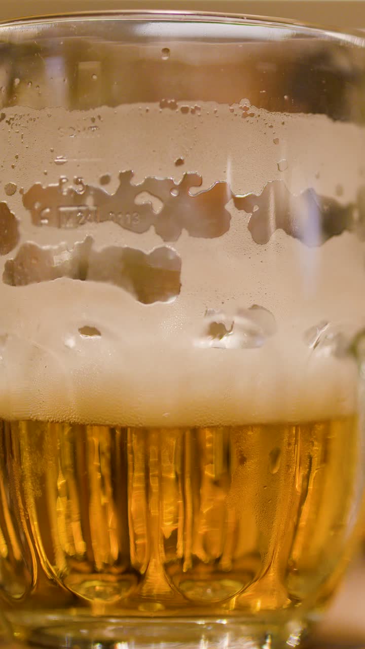 Birra lager dorata con schiuma versata in un boccale di vetro in un brewpub.