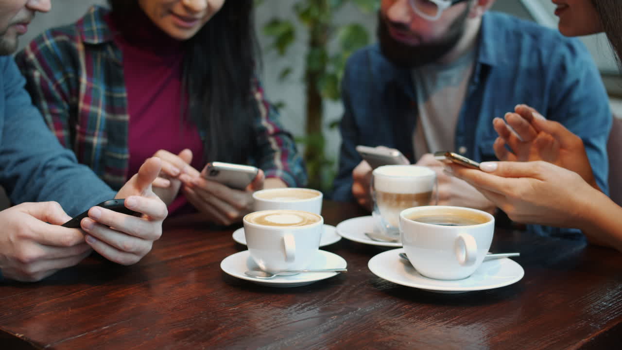 Friends Meeting in Cafe, Using Smartphones and Drinking Coffee