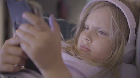 chica joven rubia con auriculares usando un teléfono inteligente