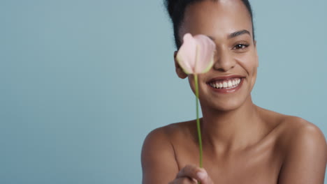 portrait beautiful young woman holding lily flower smiling enjoying healthy skincare happy female with perfect natural beauty on blue background