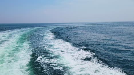 wake on turquoise ocean surface created by a sailing ship