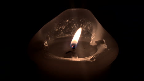 4k single candle vigil offset on black background