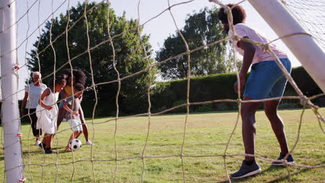 Familia-Negra-De-Varias-Generaciones-Jugando-Al-Fútbol-En-El-Jardín