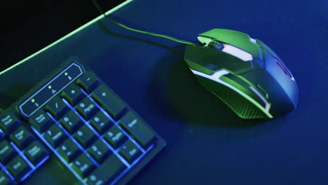 Video-of-gaming-computer-and-gaming-equipment-on-desk-with-copy-space-on-neon-background