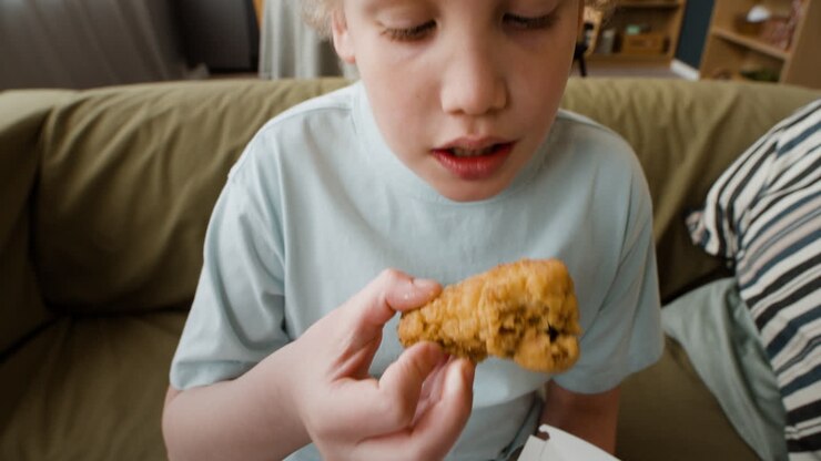 Young Boy Eating Fried Chicken