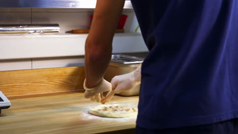 an experienced chef on a professional kitchen prepares the dough with flour to make pizza. concept of tasty food.