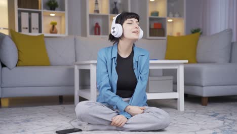 행복한 젊은 여성이 헤드폰으로 음악을 듣고 있습니다.