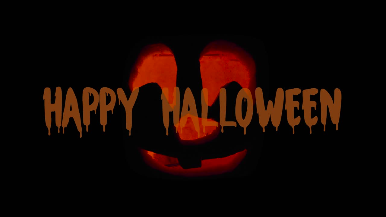 Happy Halloween Cute Jack O' Lantern glowing in the dark with Textanimation wishing Happy Halloween: carved Pumpkin decoration with burning candle inside.