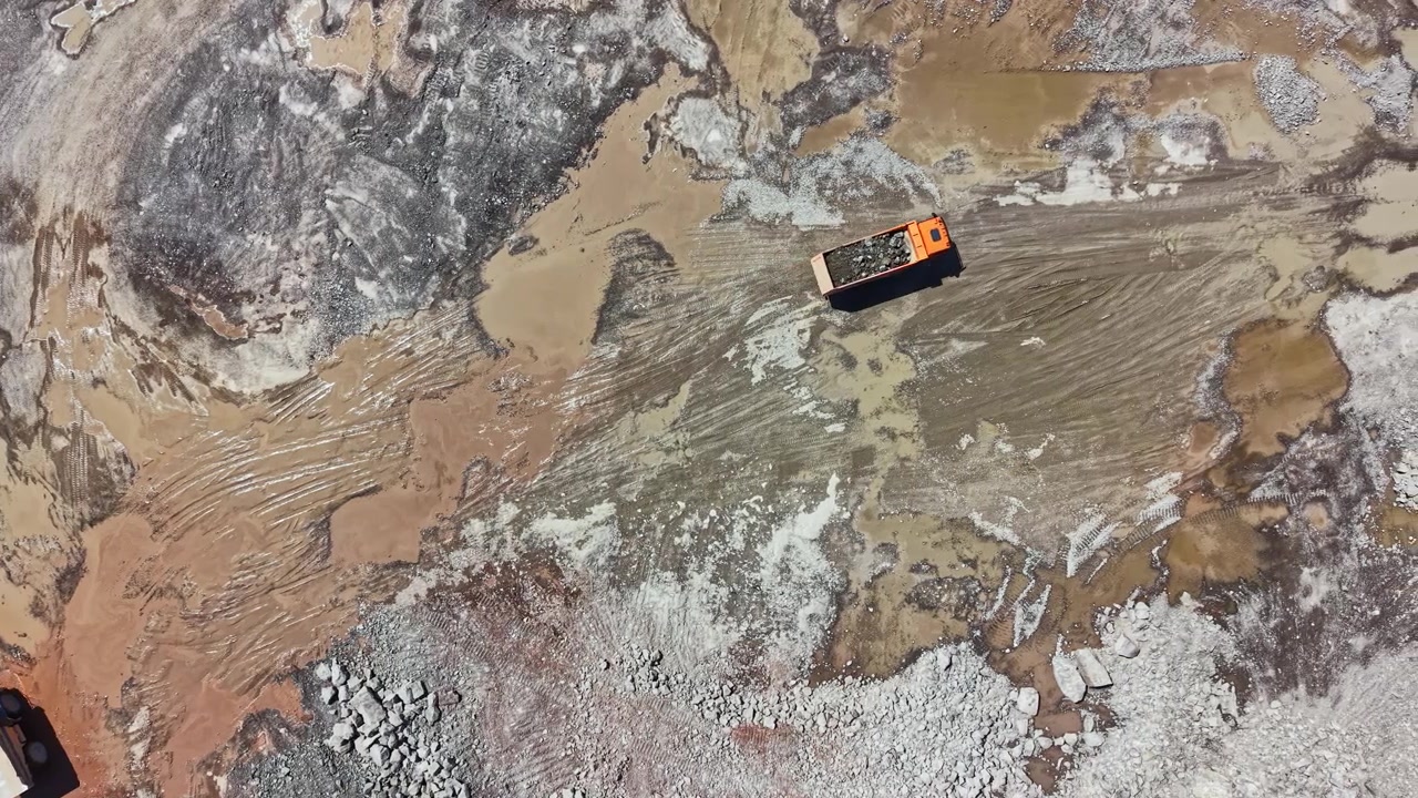 Granite quarry site with heavy machinery and extraction activity observed from above on a clear day