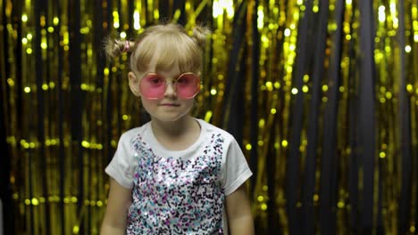 Child-kid-dancing,-celebrating-victory,-fooling-around.-Girl-posing-on-background-with-foil-curtain