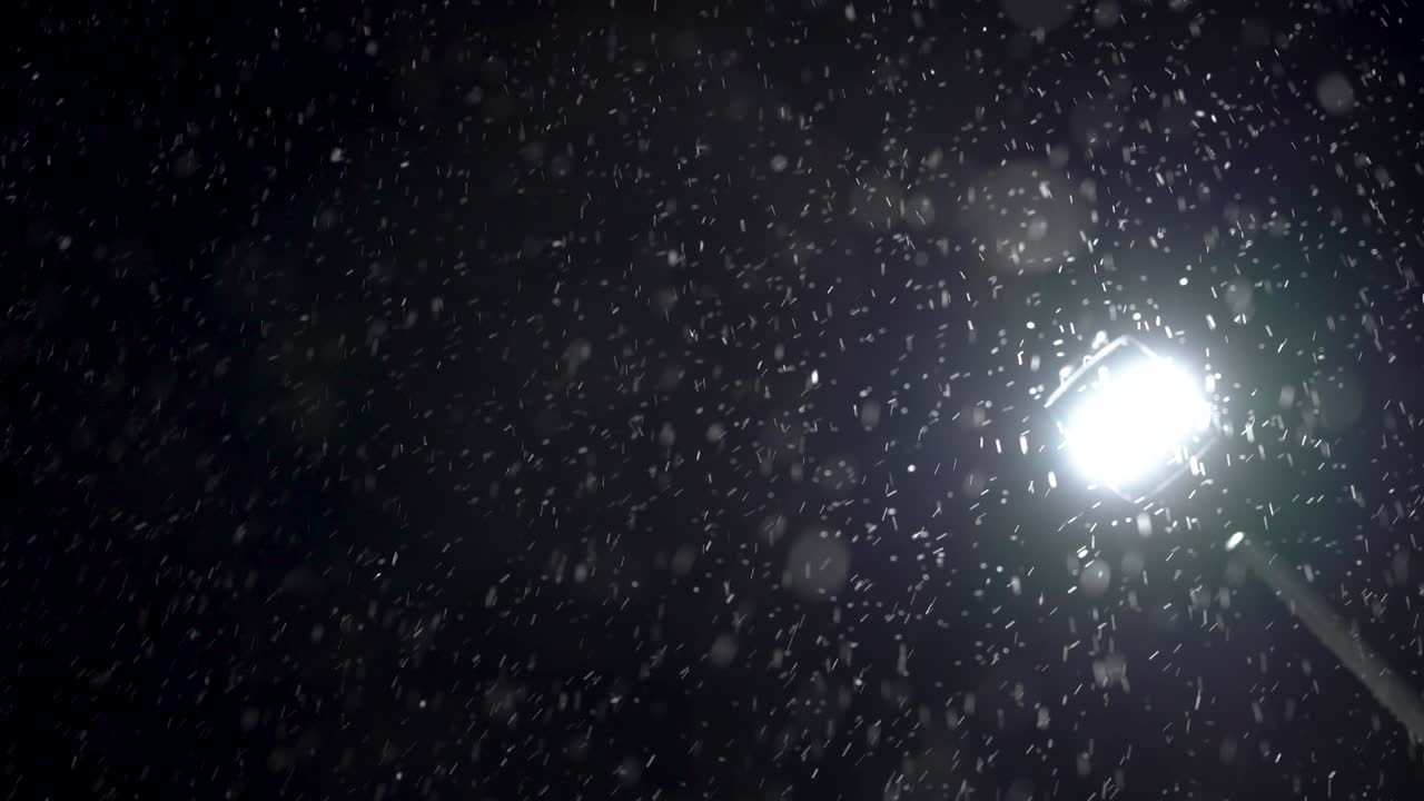 partículas en un fondo negro contra un poste de luz