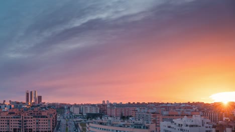 Horizonte-De-Timelapse-De-La-Moderna-Ciudad-Europea-De-Madrid-Durante-La-Puesta-De-Sol-Con-Luz-Dorada-Y-Nubes-Rojas-Durante-La-Hora-Azul-Zoom-En-El-Lapso-De-Tiempo-De-Día-A-Noche-Copia-Espacio-Regla-De-Tercios