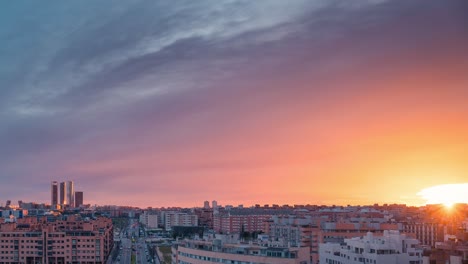 timelapse skyline of modern european city madrid during sunset with golden light and red clouds during blue hour zoom in day to night time lapse copy space rule of thirds