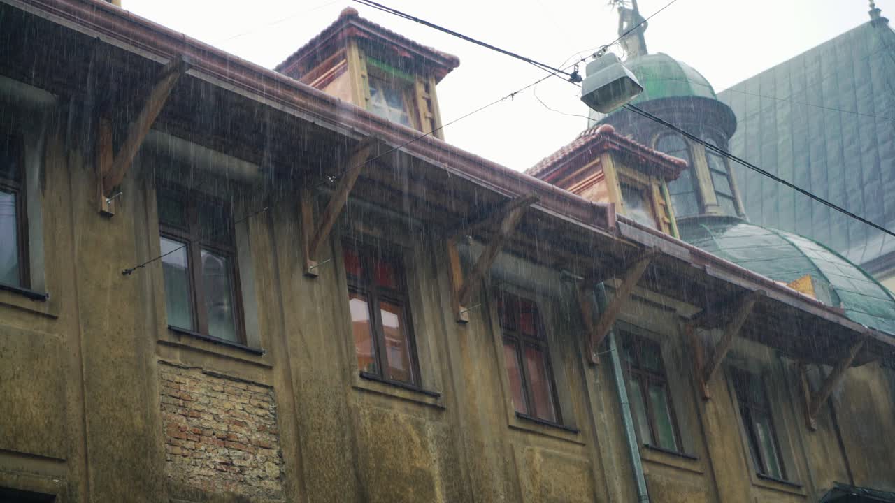 Pioggia sullo sfondo dell'architettura urbana. Gocce di pioggia cadono sullo sfondo di un vecchio edificio.