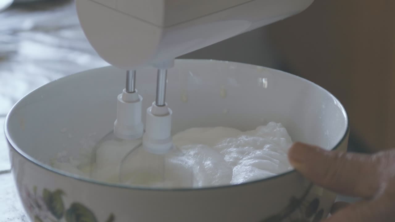 una dama mezcla azúcar, harina, mantequilla y huevos para hacer un pastel, cámara lenta de los ingredientes mezclados, manos viejas